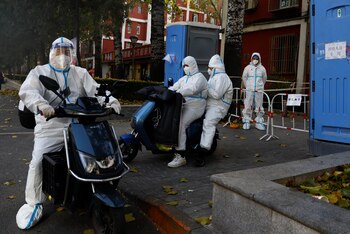 Los trabajadores con trajes protectores