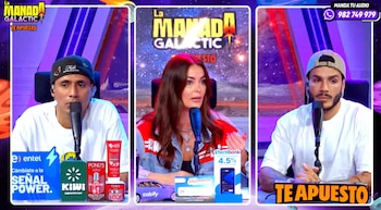 Una mujer y dos hombres sentados en un panel de televisión con micrófonos y productos publicitarios en una mesa