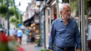 Adulto mayor experimentando soledad mientras mira vidrieras en un paseo solitario, destacando la necesidad de atención en psiquiatría y terapia para abordar el aislamiento y promover el bienestar emocional. La escena subraya la importancia de la conexión social y el apoyo psicológico. (Imagen ilustrativa Infobae)