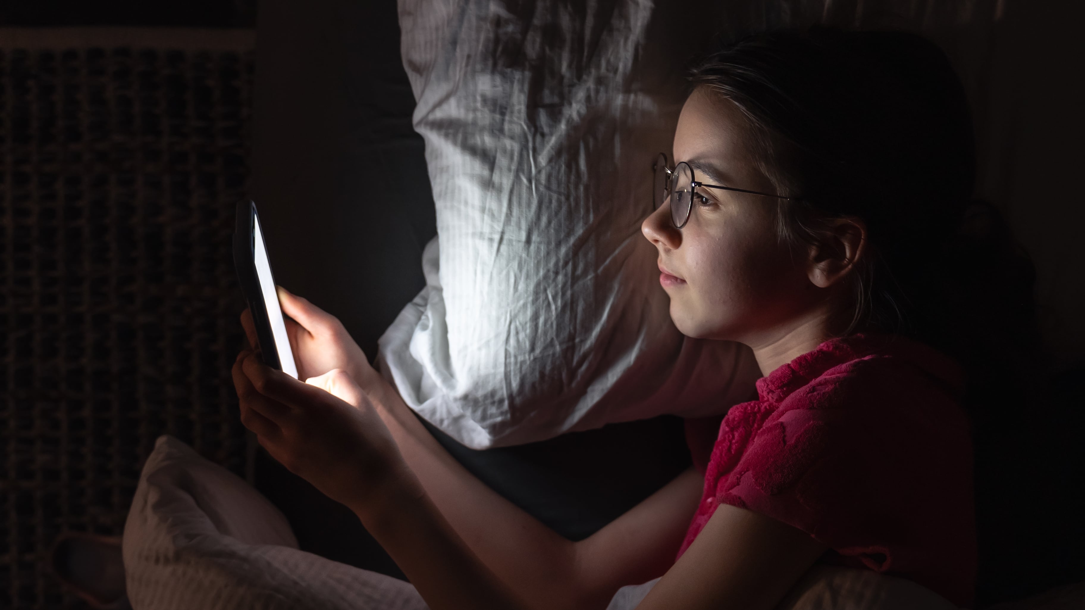 Una chica utilizando su teléfono por la noche (Magnific)