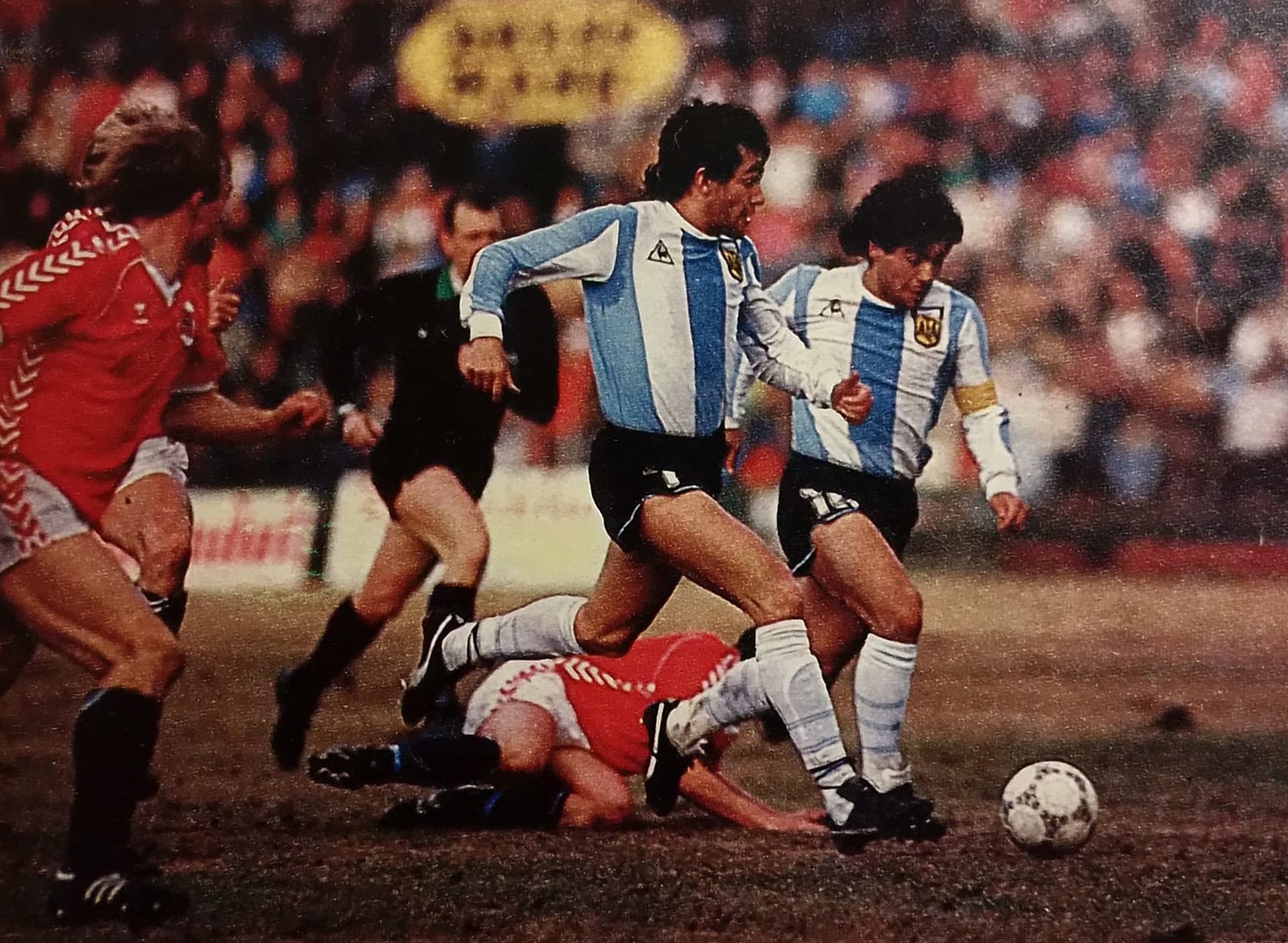 Con una particular camiseta, Maradona y Burruchaga maniobran en la increíble derrota frente a Noruega