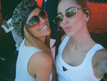 Dos mujeres posan para una selfie de cerca: una con gafas de sol oscuras y boina de leopardo, la otra con gafas de sol claras y haciendo un beso