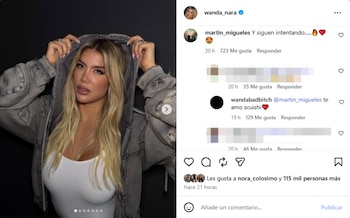 Wanda Nara, con cabello rubio largo, posa usando un top blanco y una chaqueta gris con capucha, mostrando un maquillaje pronunciado en labios y ojos