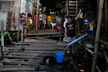 Una mujer utiliza una bomba de agua manual en una barriada en Muntinlupa, Filipinas, el 21 de marzo de 2023. (AP Foto/Aaron Favila)
