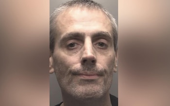 Primer plano de un hombre con cabello gris claro y barba de tres días. Mira directamente al frente. Tiene ojos oscuros. El fondo es liso y claro