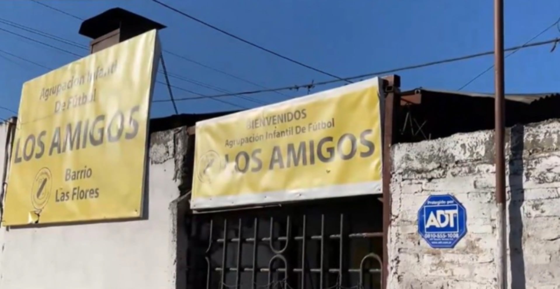La fachada del Club Los Amigos en barrio Las Flores, Rosario, exhibe sus carteles de bienvenida y un cartel de seguridad tras un intento de robo donde un vecino resultó baleado (Rosario3)