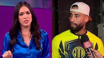 Jazmin Pinedo, de blusa satinada azul, a la izquierda, y Jota Benz, con gorra blanca y camiseta amarilla, a la derecha, sosteniendo un micrófono.