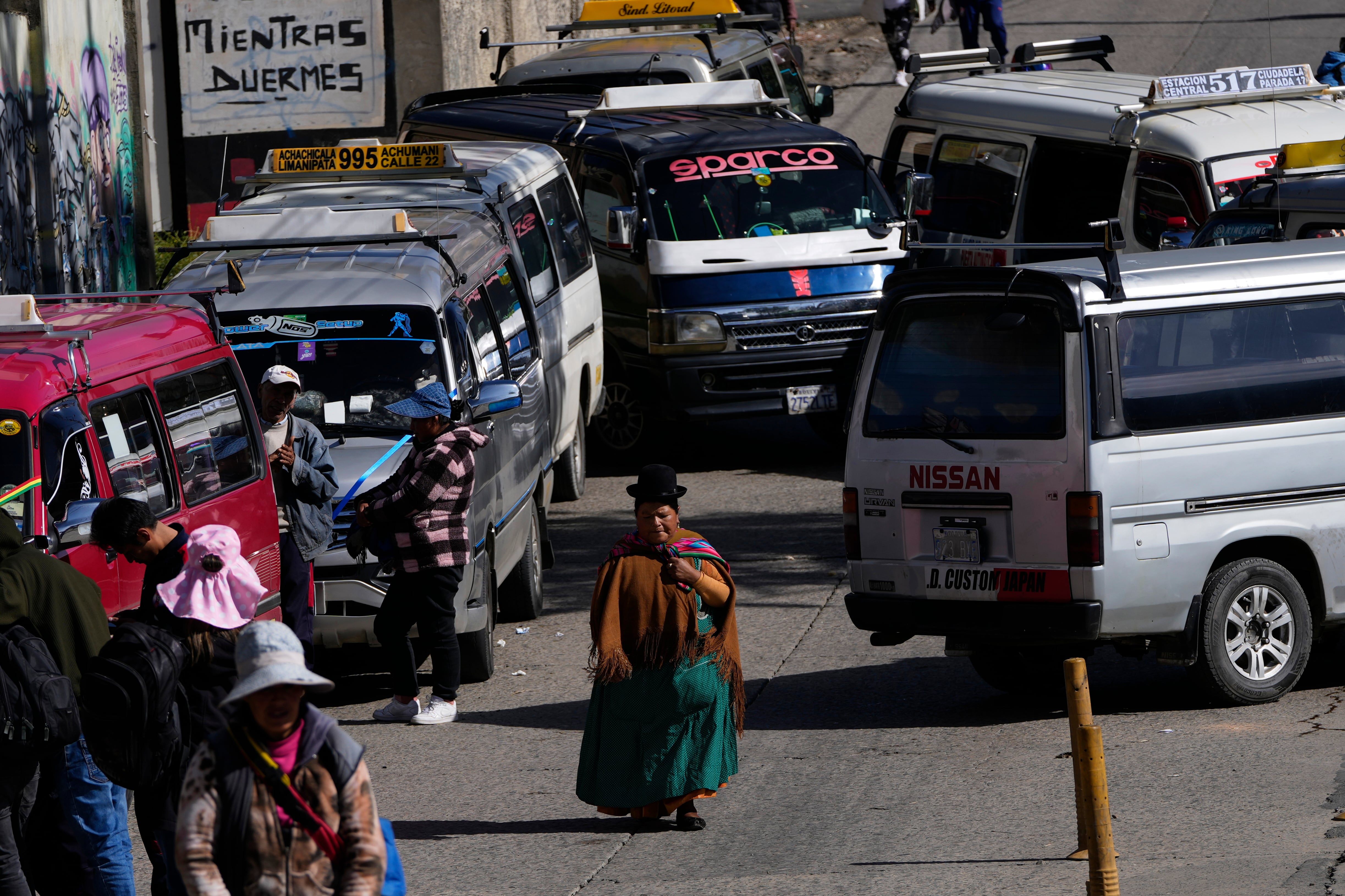 Una mujer camina en medio de un bloqueo de transportistas en El Alto, Bolivia. 25 de marzo de 2026. (AP Photo/Juan Karita)