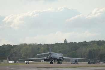 Policías custodian una ruta que conduce a la base aérea estadounidense RAF Fairford, en Fairford, Inglaterra, el 27 de septiembre de 2026. Los tres furgones hallados cerca del lugar fueron examinados por un robot antes de ser retirados (AP Foto/Alastair Grant)