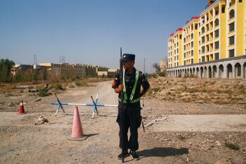 Un oficial de policía chino en su puesto en la carretera cerca de lo que oficialmente se llama un centro de educación vocacional en Yining, en la Región Autónoma Uigur de Xinjiang, China, el 4 de septiembre de 2018. (REUTERS/Thomas Peter)