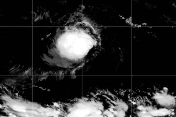 Una masa circular de nubes blancas sobre la superficie oscura del océano con líneas de cuadrícula y coordenadas