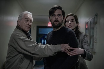 Robert De Niro, Adam Scott y Michelle Monaghan están en un pasillo. De Niro toca el brazo de Scott y Monaghan pone sus manos en la espalda de Scott