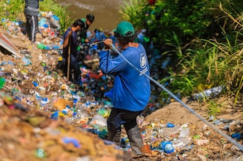 Trabajadores municipales de San Salvador Centro realizan labores de limpieza y retiro de desechos plásticos acumulados en las riberas de una quebrada, como parte de las acciones preventivas ante la temporada invernal (Foto cortesía @DesechoSolidos).