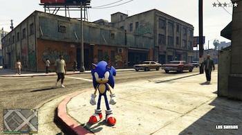 Sonic el erizo azul de pie en una acera de una calle de la ciudad con edificios con grafitis, coches y personas al fondo.