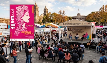 Un cartel rosado de FILEM 2026 a la izquierda y una vista de la feria del libro con puestos, público y un escenario en una plaza
