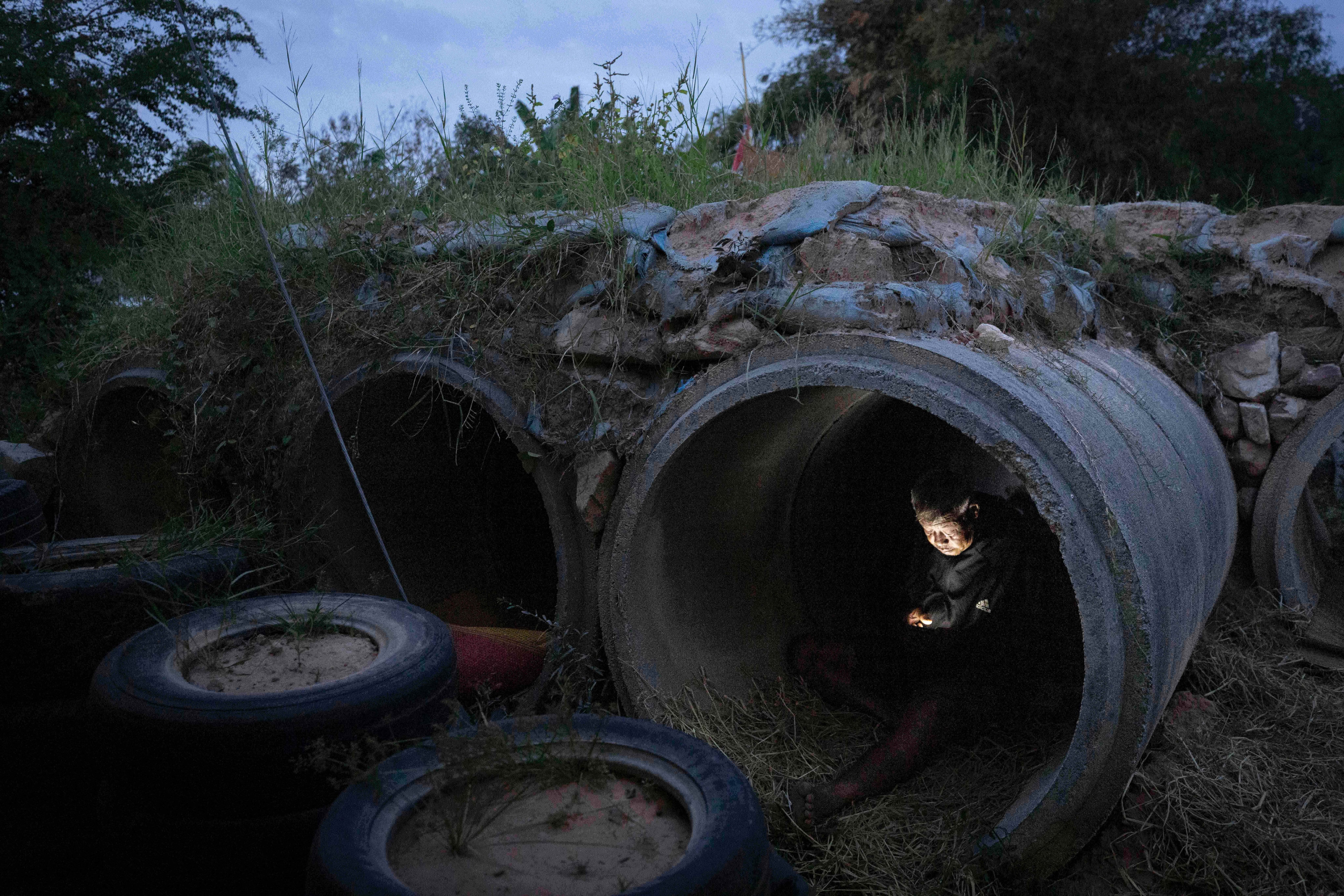 Un tailandés que huyó de enfrentamientos entre soldados tailandeses y camboyanos utiliza su celular mientras se refugia en la provincia de Buriram, Tailandia, el martes 9 de diciembre de 2025. (AP Foto/Wason Wanichakorn)