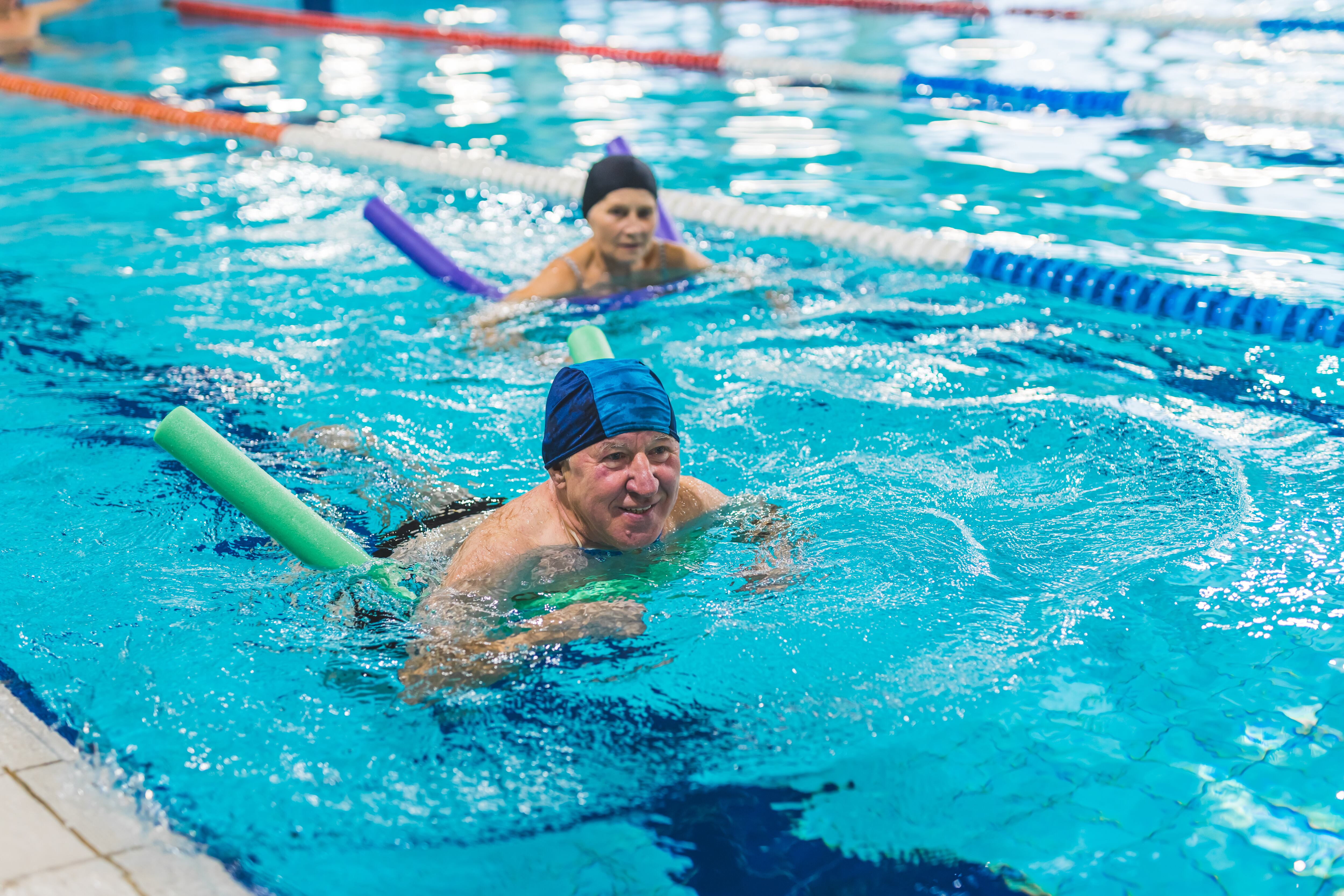 Una pareja practicando ejercicio aeróbico en natación (AdobeStock)