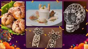 Composición con pan dulce, un postre blanco, pendientes metálicos con calaveras, un cráneo decorado y flores de cempasúchil con velas.