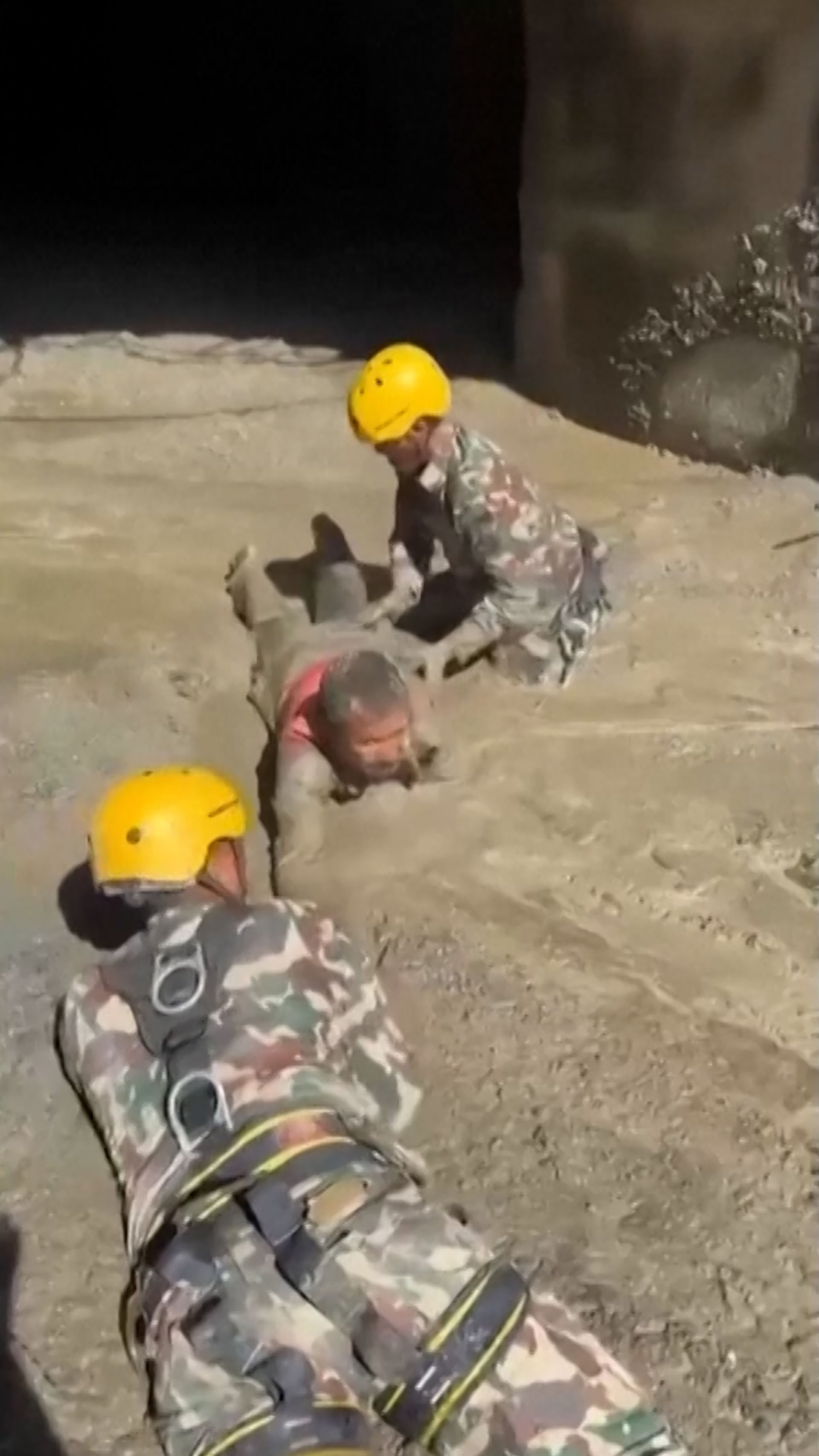 Personal de salvamento en Nepal avanza sobre el terreno cubierto de lodo para auxiliar a una persona atrapada (Captura de video)