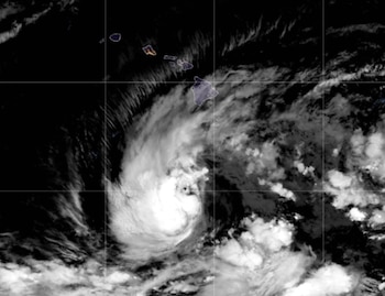 Fotografía satelital en blanco y negro de una masa circular de nubes sobre el océano Pacífico junto a las islas de Hawái