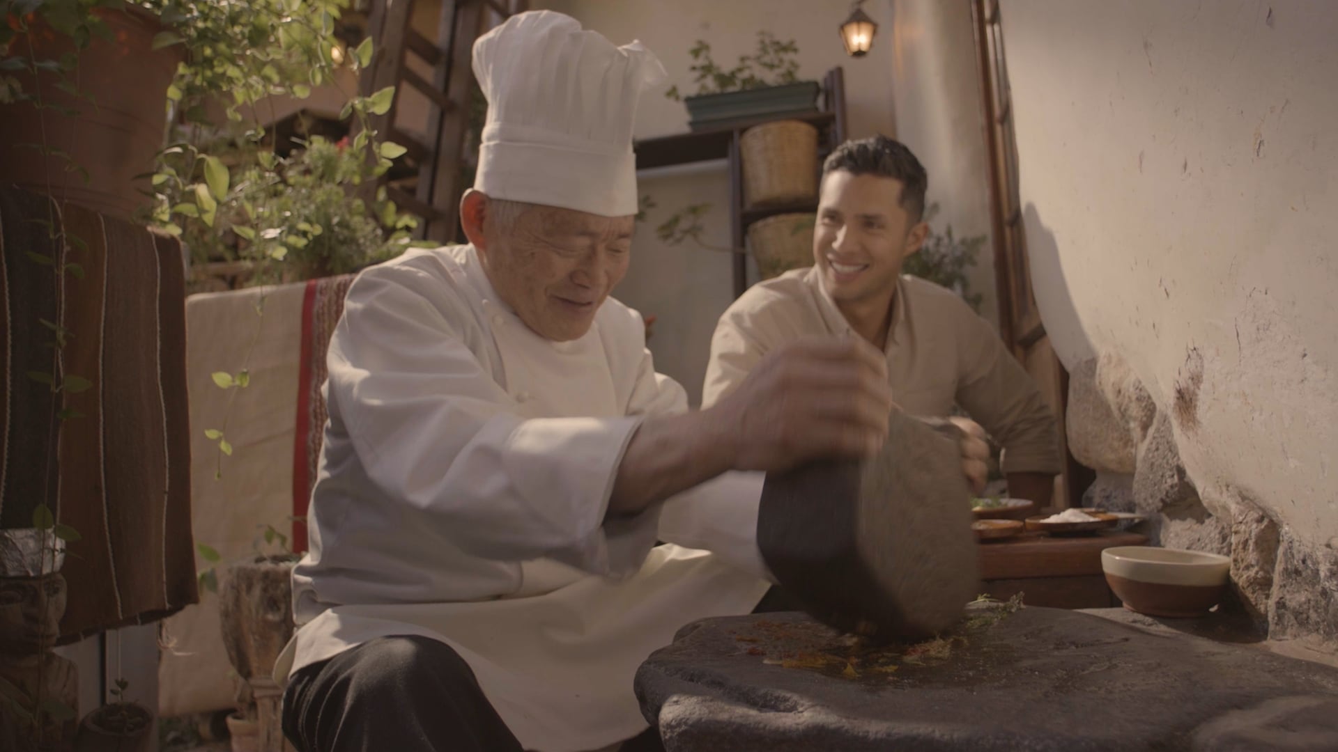 El chef Rodrigo Fernandini observa la molienda de ingredientes en un batán tradicional durante una escena de la película peruana Ceviche.