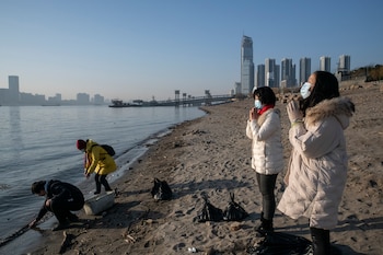 People pray along the banks