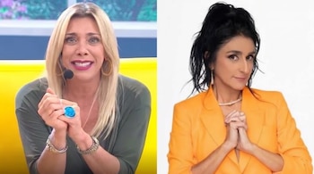 Cynthia Klitbo, con cabello rubio y micrófono, y Bárbara Torres, con cabello oscuro y chaqueta naranja, ambas con las manos unidas.