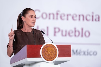Claudia Sheinbaum Pardo, con el cabello recogido y blusa marrón, hablando ante un micrófono en un podio con el escudo de Estados Unidos Mexicanos
