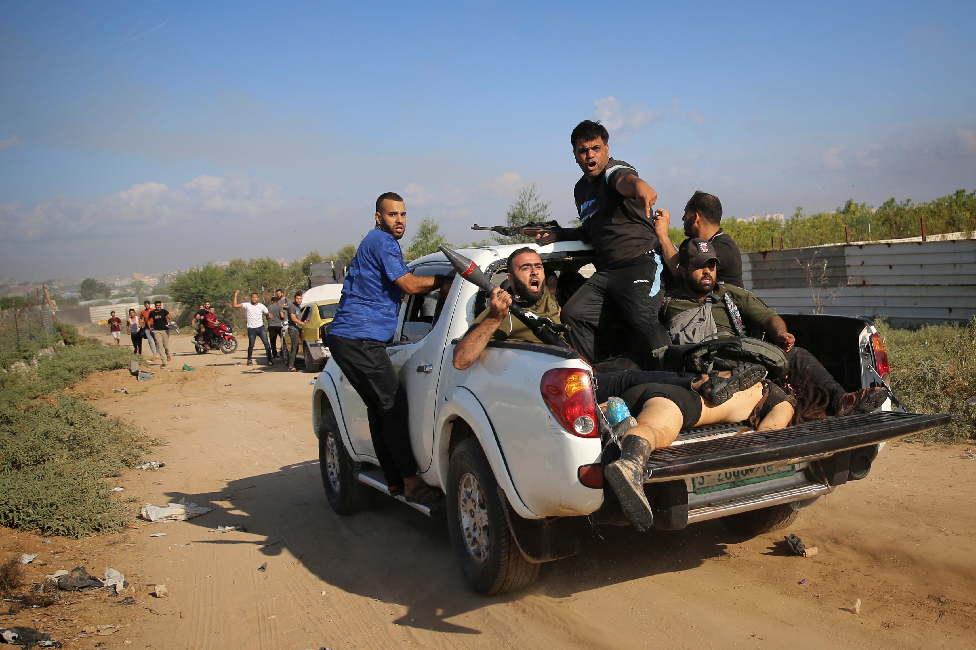 Terroristas regresan a la Franja de Gaza en una camioneta con el cuerpo de Shani Louk, una joven con doble nacionalidad israelí y alemana secuestrada en una fiesta eletrónica, el 7 de octubre de 2023 (AP Foto/Ali Mahmud)