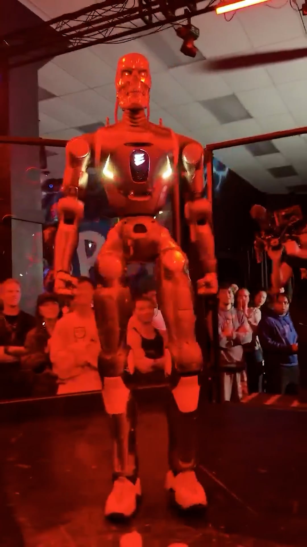 El robot REK permanece en el centro del cuadrilátero durante un evento de artes marciales mixtas frente al creador de contenido Frankie LaPenna.