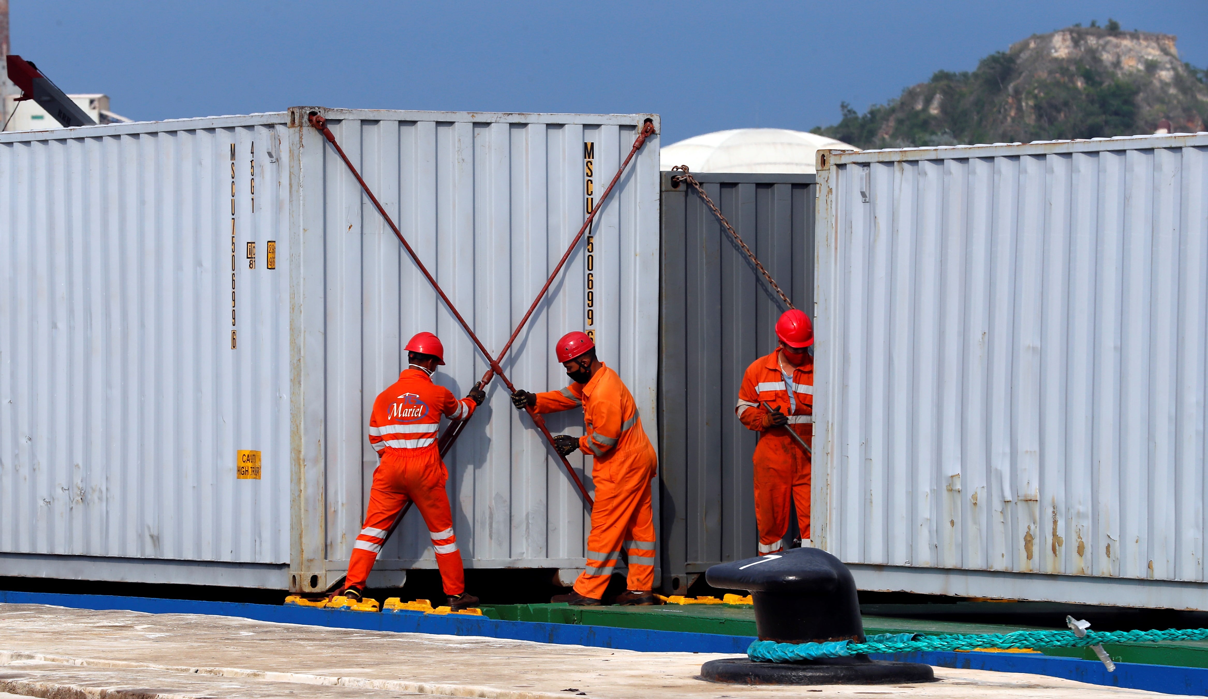Trabajadores descargan los contenedores de un barco cargado de ayuda humanitaria, en el puerto de Mariel, en La Habana (EFE/Ernesto Mastrascusa/Archivo)