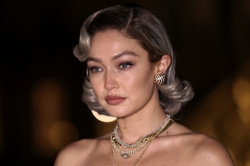 Los pendientes de aro dorados y los collares con detalles simbólicos elevan la propuesta de Gigi Hadid (REUTERS/Gonzalo Fuentes)