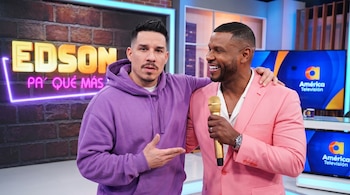 Dos hombres en un estudio. Uno en traje rosa sostiene un micrófono, el otro en sudadera morada. Atrás, letrero "EDSON PA' QUÉ MÁS" y logos de América Televisión.
