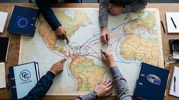 Vista superior de un mapa con rutas trazadas, varias manos señalando la superficie y carpetas institucionales a los lados.