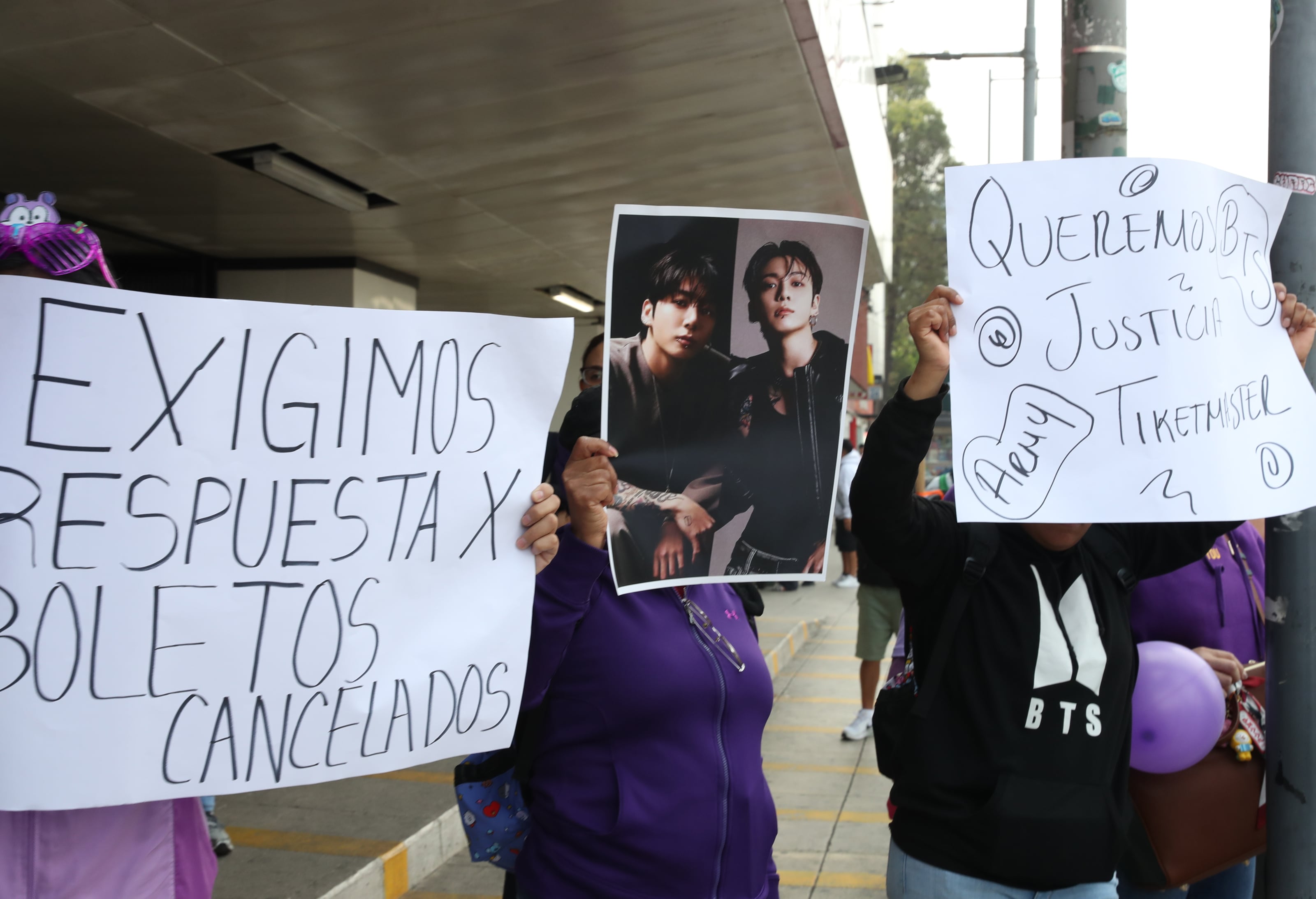 Seguidora del grupo de k-pop BTS muestran carteles con imágenes de la banda y gritan consignas este viernes, durante una marcha en Ciudad de México (México). EFE/Mario Guzmán