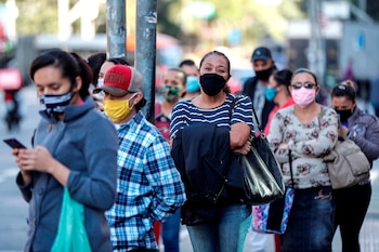 Personas hacen fila mientras esperan