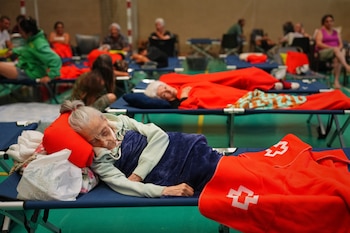 Unos residentes pasan la noche en un polideportivo tras ser evacuados de sus hogares debido a la amenaza de un incendio forestal en Cebreros, provincia de Ávila, España, el viernes 24 de julio de 2026 (AP/Manu Fernandez)