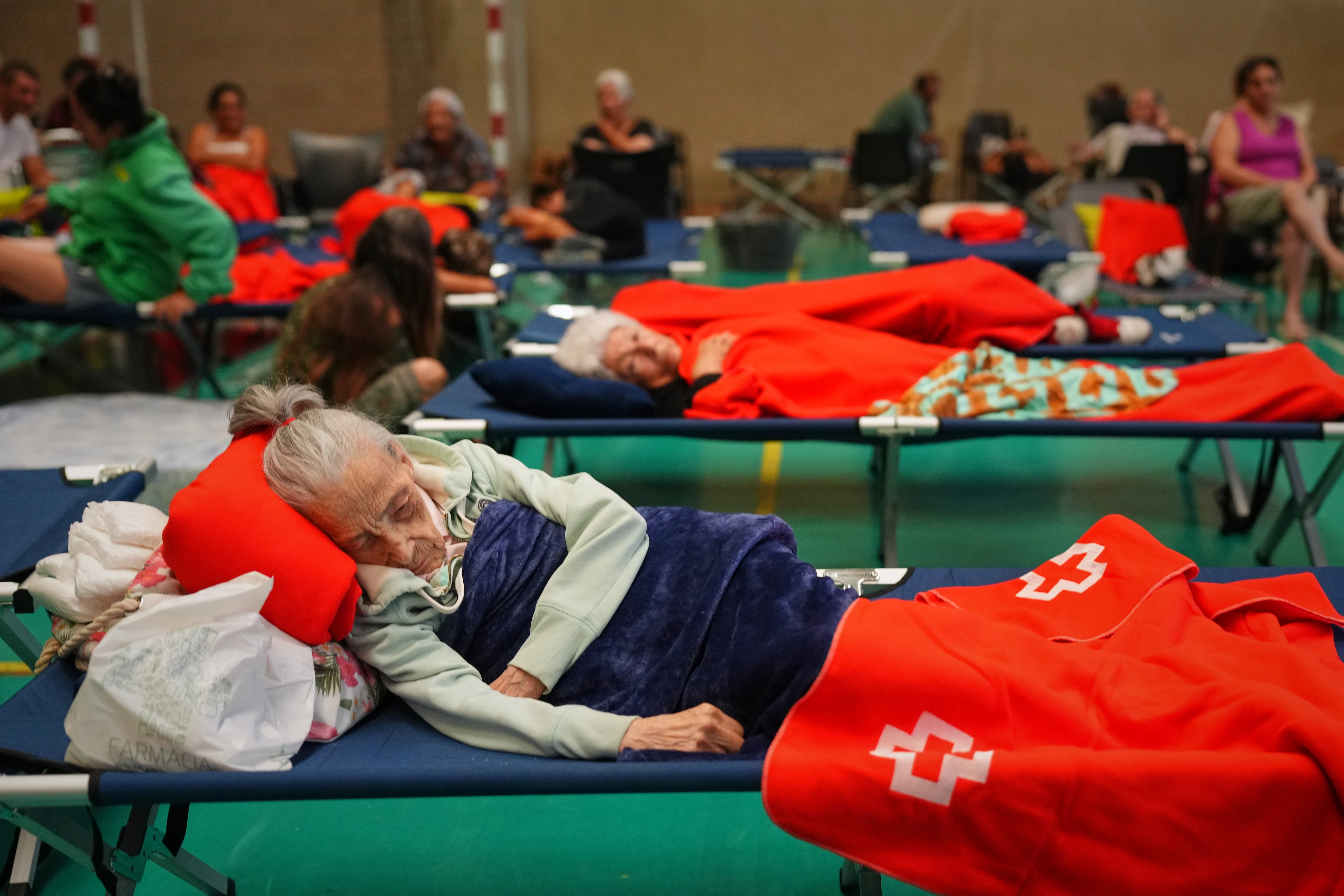 Unos residentes pasan la noche en un polideportivo tras ser evacuados de sus hogares debido a la amenaza de un incendio forestal en Cebreros, provincia de Ávila, España, el viernes 24 de julio de 2026 (AP/Manu Fernandez)