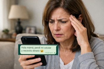 Una mujer con expresión de preocupación sostiene un teléfono inteligente negro en sus manos. En la pantalla se ve un mensaje de WhatsApp verde que dice: "Hola mamá, perdí mi celular y necesito dinero".
