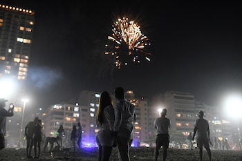 Una pareja contempla los fuegos artificiales de año nuevo en Rio de Janeiro en plena pandemia de covid-19
