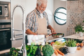 Un hombre mayor cocinando (AdobeStock)