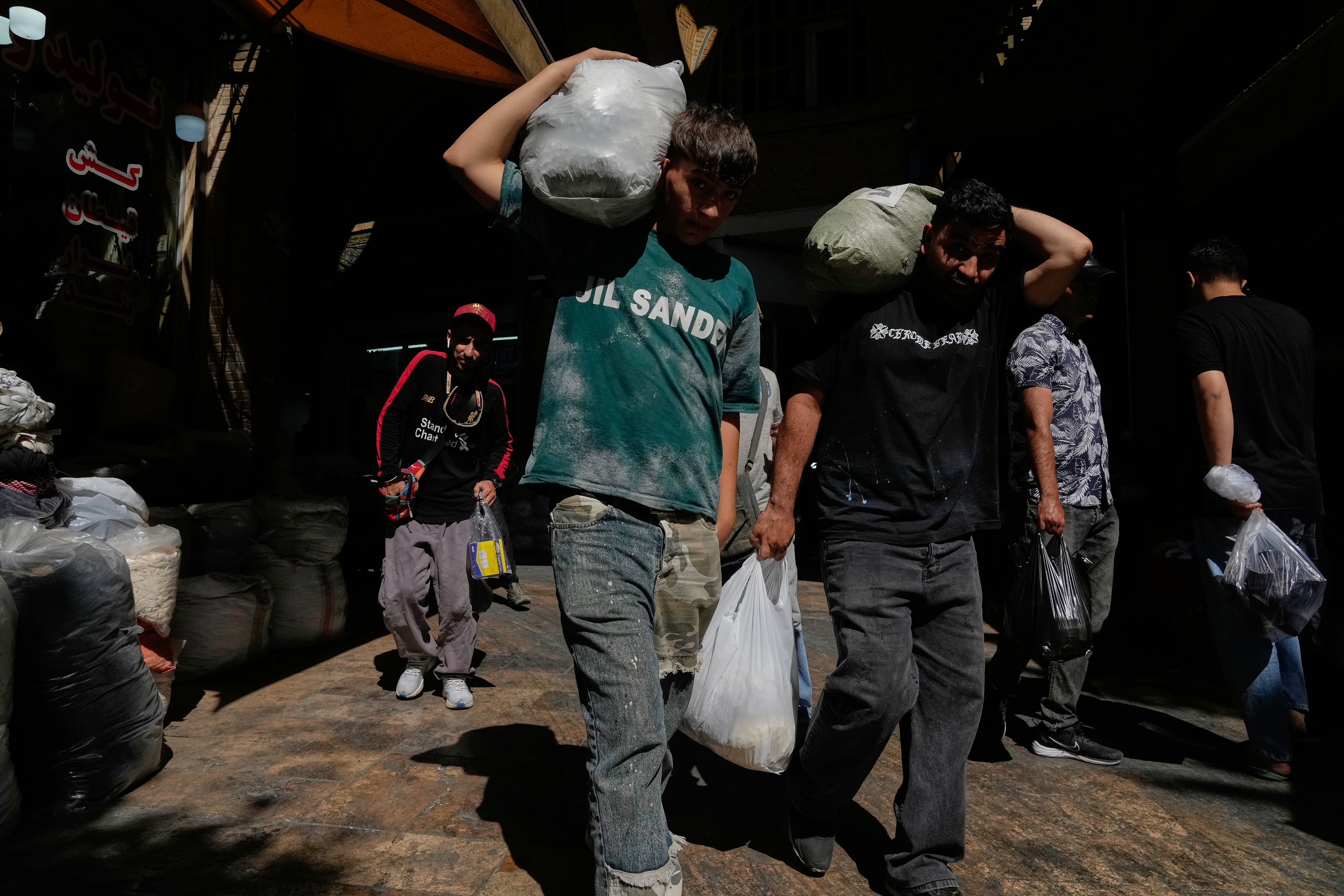 Compradores acarrean paquetes en el histórico Gran Bazar de Teherán, el lunes 1 de junio de 2026. La inflación interanual en Irán alcanzó el 77,2% en mayo, el nivel más alto desde la Segunda Guerra Mundial. (AP Photo/Vahid Salemi)
