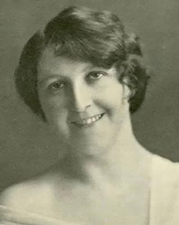 Fotografía en sepia del rostro de una mujer sonriente con cabello corto ondulado