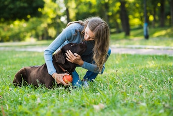 Una mujer jugando con su perro (Magnific)