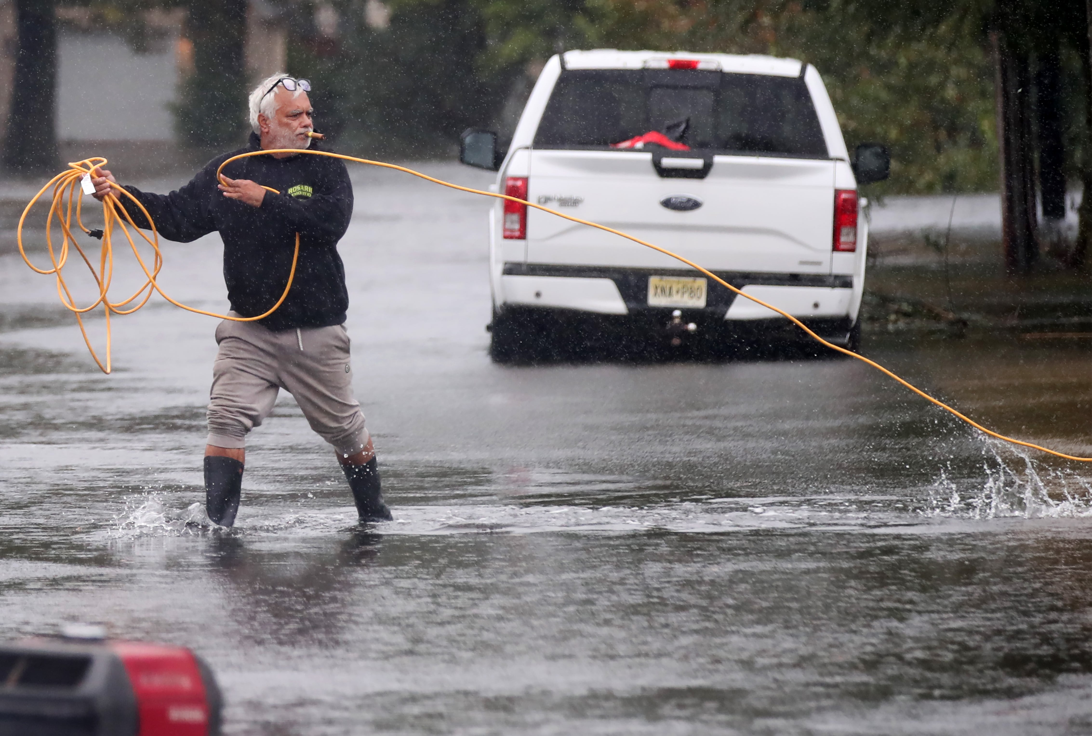 Jose Rosario saca un cable de extensión de su garaje inundado para conectarlo a un generador en la calle Catherine, el sábado 26 de septiembre de 2026, en Long Branch, Nueva Jersey (AP /Noah K. Murray)