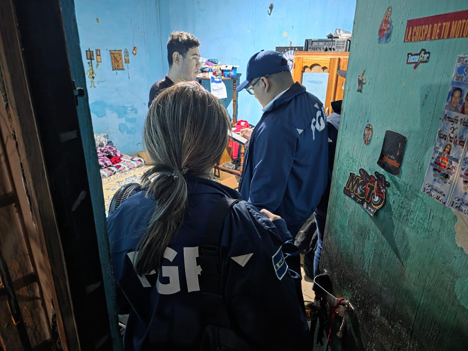 Personal de la Fiscalía General de la República realiza diligencias durante un allanamiento en una vivienda de Apopa, como parte del operativo que dejó 17 capturas vinculadas a delitos de extorsión y robo.