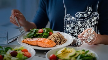 Persona cenando salmón a la plancha, quinoa y ensalada de espinacas y tomate. Una ilustración transparente del intestino con bacterias se superpone a la imagen.