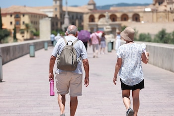Personas caminando por el Puente Romano de Córdoba bajo el calor. (Rocío Ruz/Europa Press)