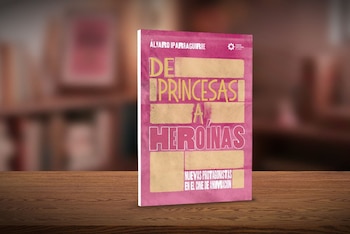 Un libro de tapa magenta y letras amarillas titulado 'De Princesas a Heroínas', sobre una mesa de madera. Al fondo hay estantes borrosos con libros