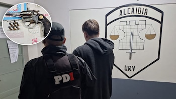 Oficial de policía de espaldas junto a un joven de hoodie gris de espaldas en una sala con escudo policial; inserto circular muestra un revólver y balas